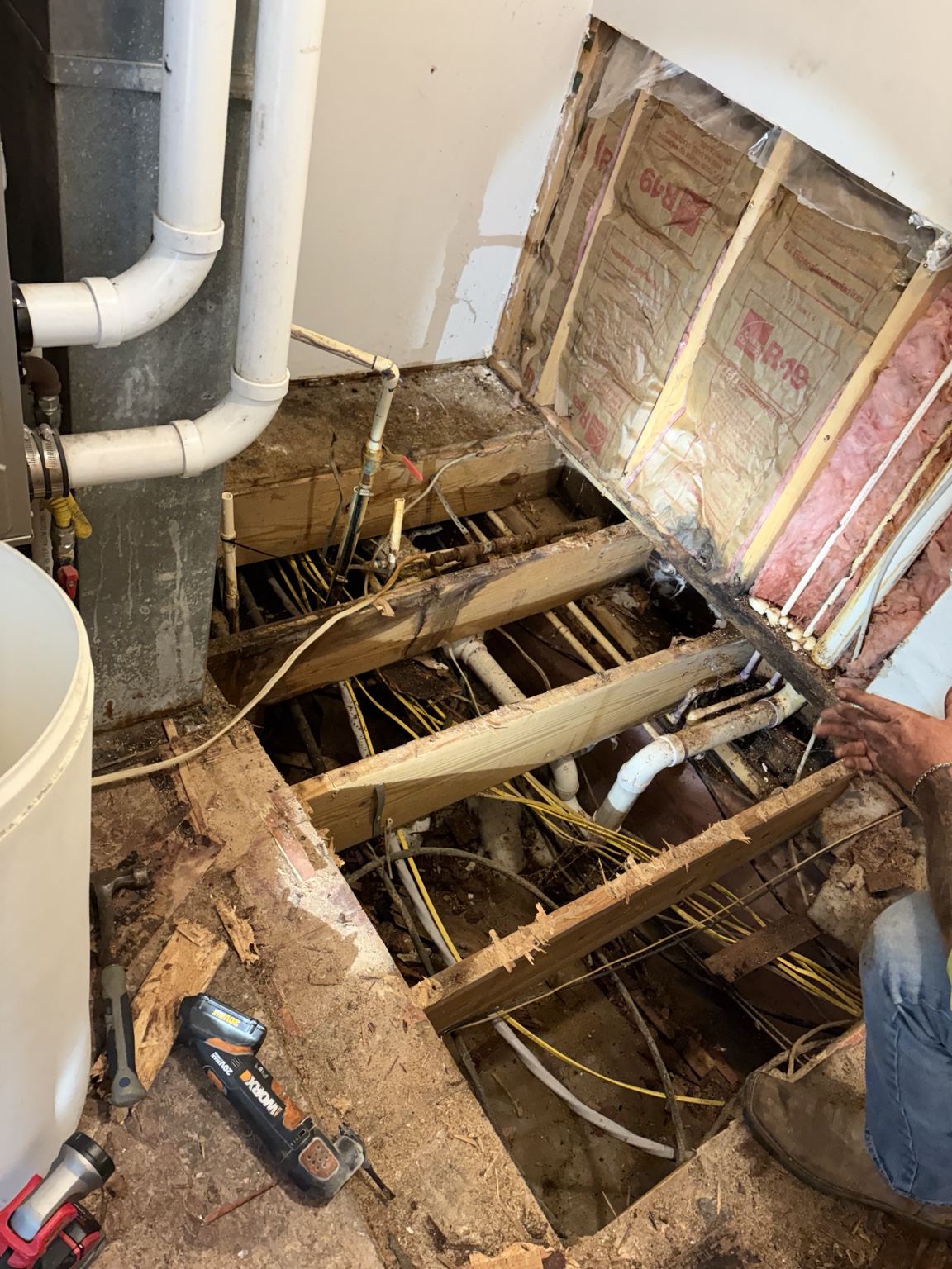 Open subfloor showing plumbing electrical wiring and floor framing